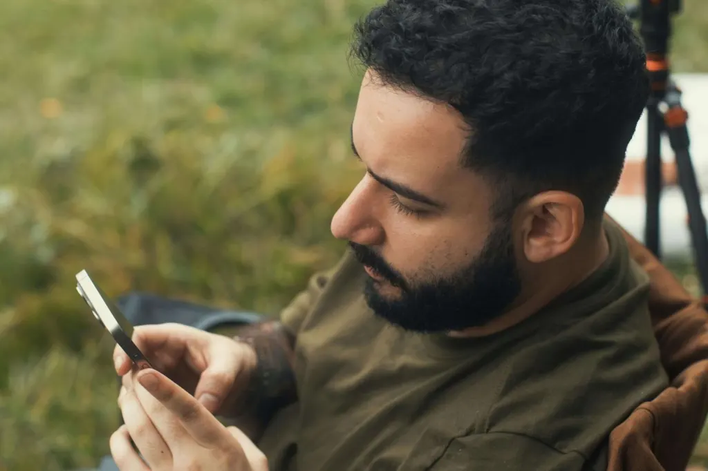 A man with a beard looking at his phone | men's therapy san francisco, ca | men's counseling san francisco, ca | online men's issues counseling california | 94607 | 94608 | 94609